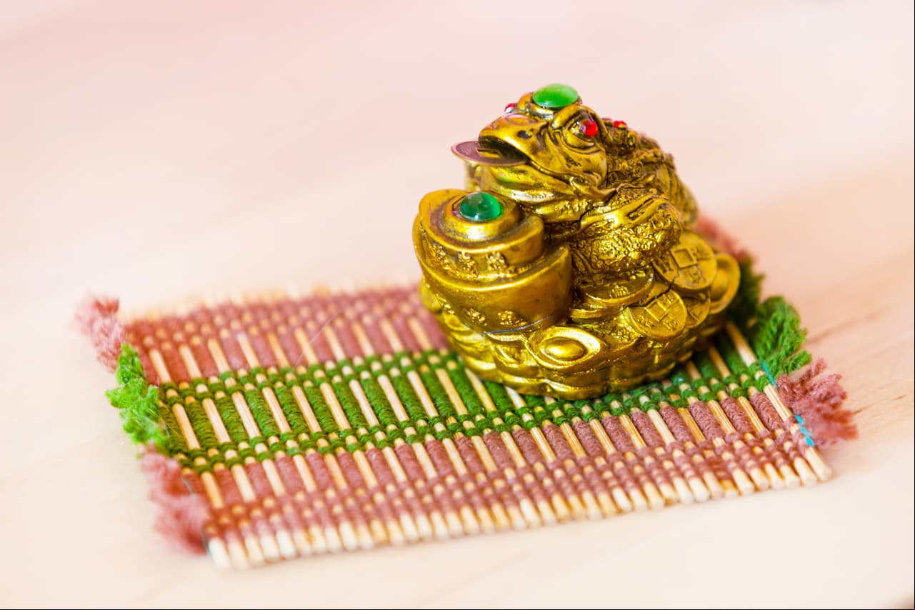 Pon figuras de sapos en la puerta de tu hogar, según el Feng Shui estos animales atraen el dinero. La tradición china, dicta poner una vieja olla rota de barro boca abajo junto a una fuente de agua para invitar al sapo.