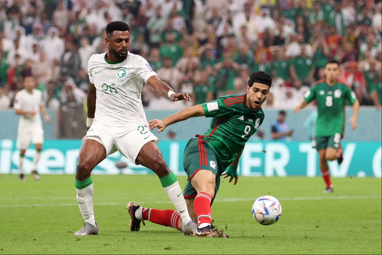 LUSAIL CITY, QATAR - NOVEMBER 30: Raul Jimenez of Mexico is fouled by Riyadh Sharahili of Saudi Arabia during the FIFA World Cup Qatar 2022 Group C match between Saudi Arabia and Mexico at Lusail Stadium on November 30, 2022 in Lusail City, Qatar. (Photo by Michael Steele/Getty Images)