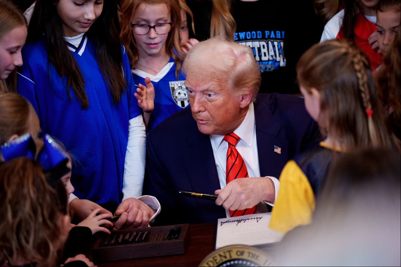 WASHINGTON, DC - FEBRUARY 05: U.S. President Donald Trump hands out pens to girls after g the "No Men in Women's Sports" executive order in the East Room of the White House on February 5, 2025 in Washington, DC. The executive order, which Trump signed on National Girls and Women in Sports Day, prohibits transgender women from competing in women's sports and is the third order he has signed that targets transgender people. (Photo by Andrew Harnik/Getty Images)